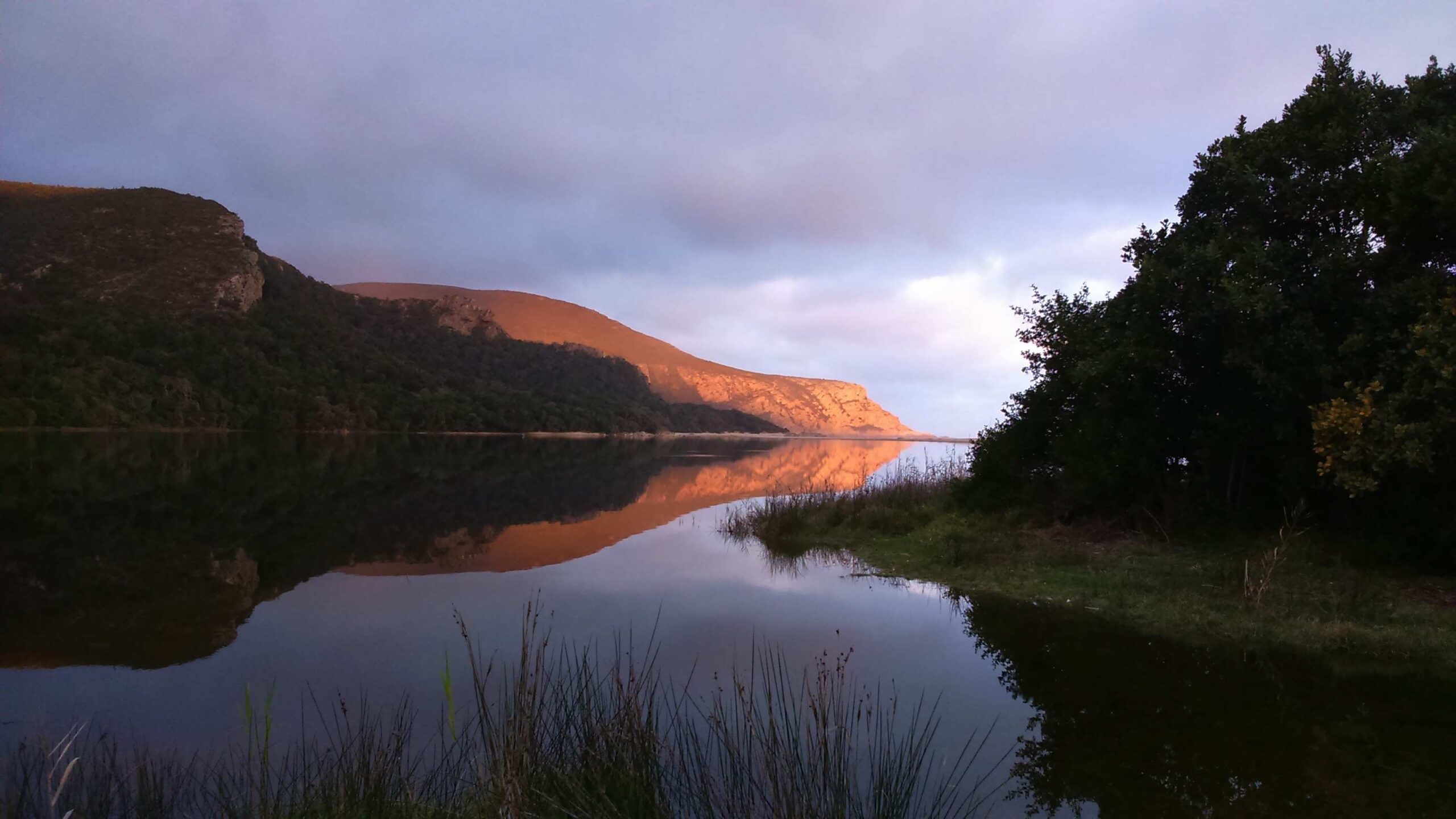 Nature's Valley lagoon and nearby hills on a peaceful evening, reflections on the water
