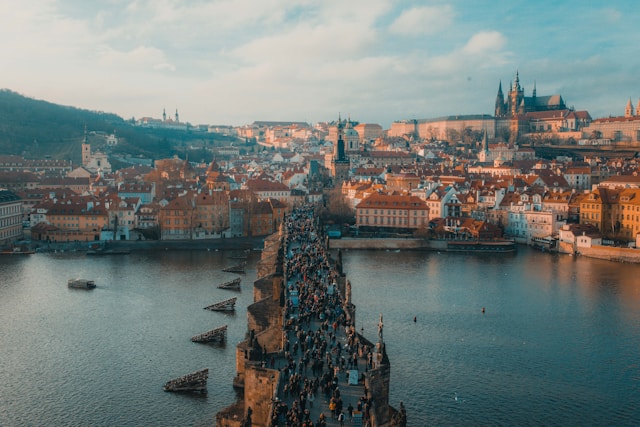 people walk across the medieval charles bridge in prague czech republic