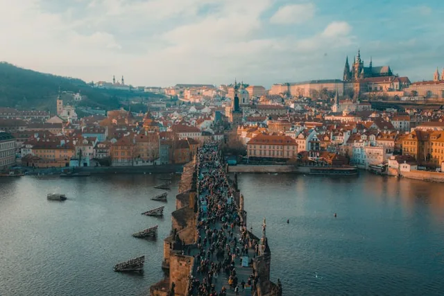people walk across the medieval charles bridge in prague czech republic