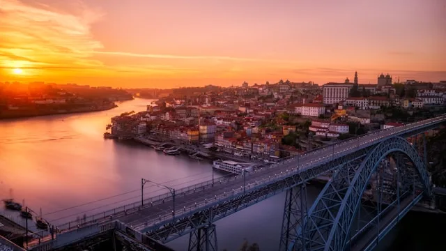 sunset over the douro river in porto portgual with the ribeiro in the background and pont luis I bridge in the foreground