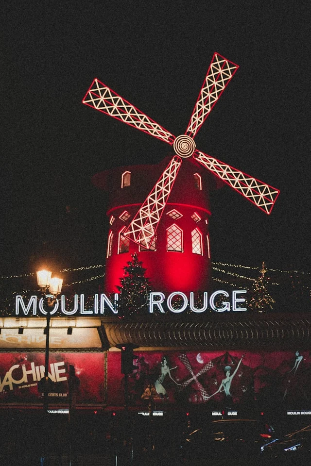 a red windmill on top of the moulin rouge bar in paris france