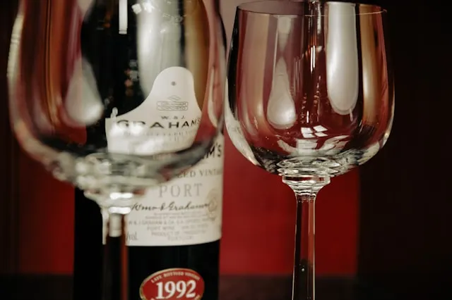 two wine glasses in front of a bottom of graham's port wine from porto portugal