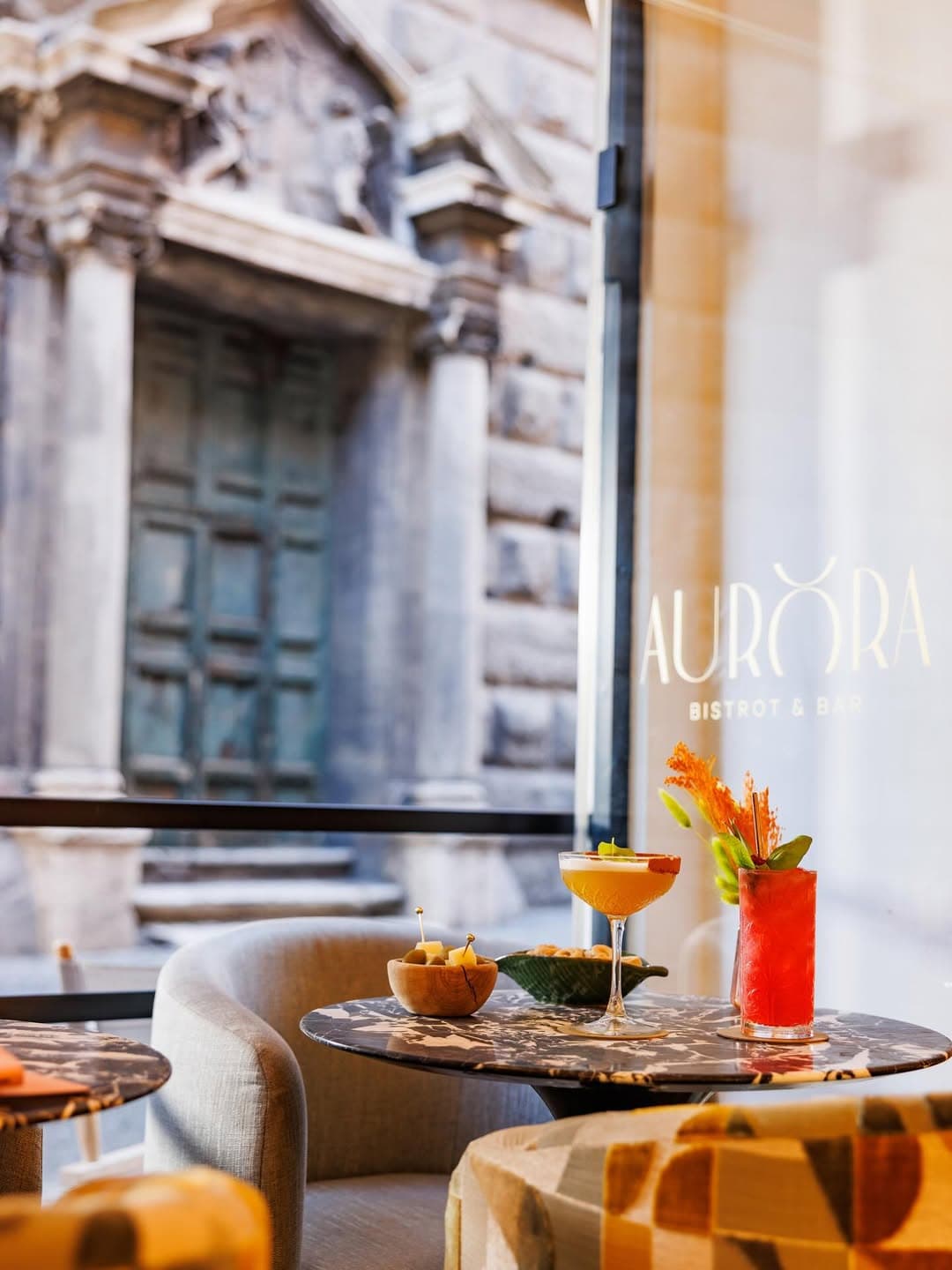 Stylish interiors from Aurora restaurant in Rome, looking out to old Roman buildings