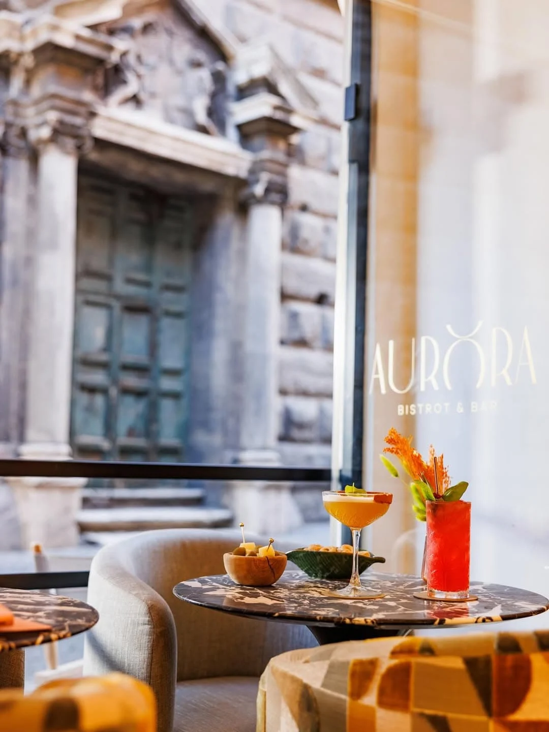 Stylish interiors from Aurora restaurant in Rome, looking out to old Roman buildings