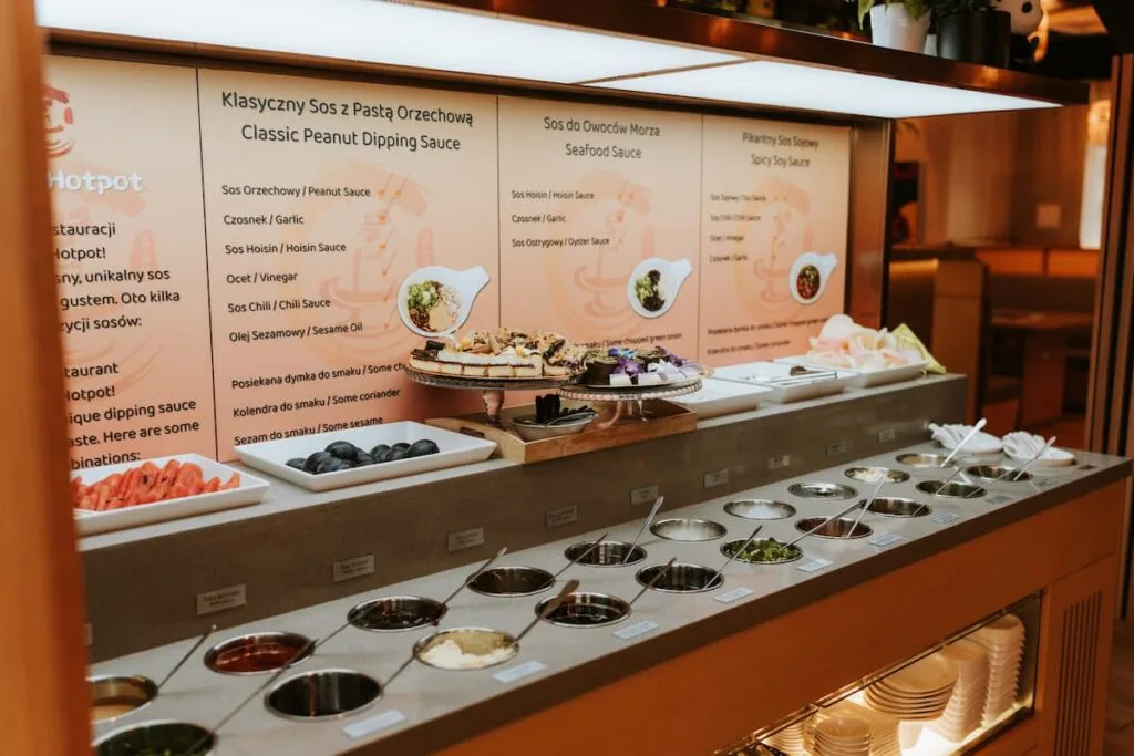 a menu behind pots of sauces at miss hotpot a szechuan hotpot restaurant in gdansk poland
