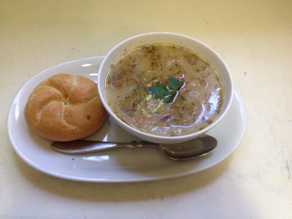 sour soup in a white bowl with a bread roll from perla baltyka one of the best restaurants in gdansk poland