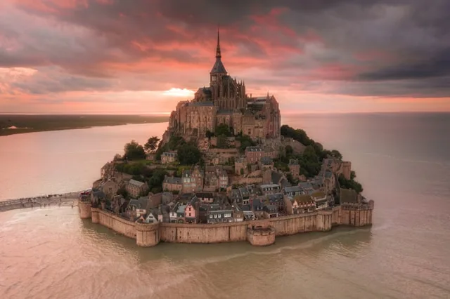 mont st michel is a small tidal island off the coast of normandy france with an abbey at its center