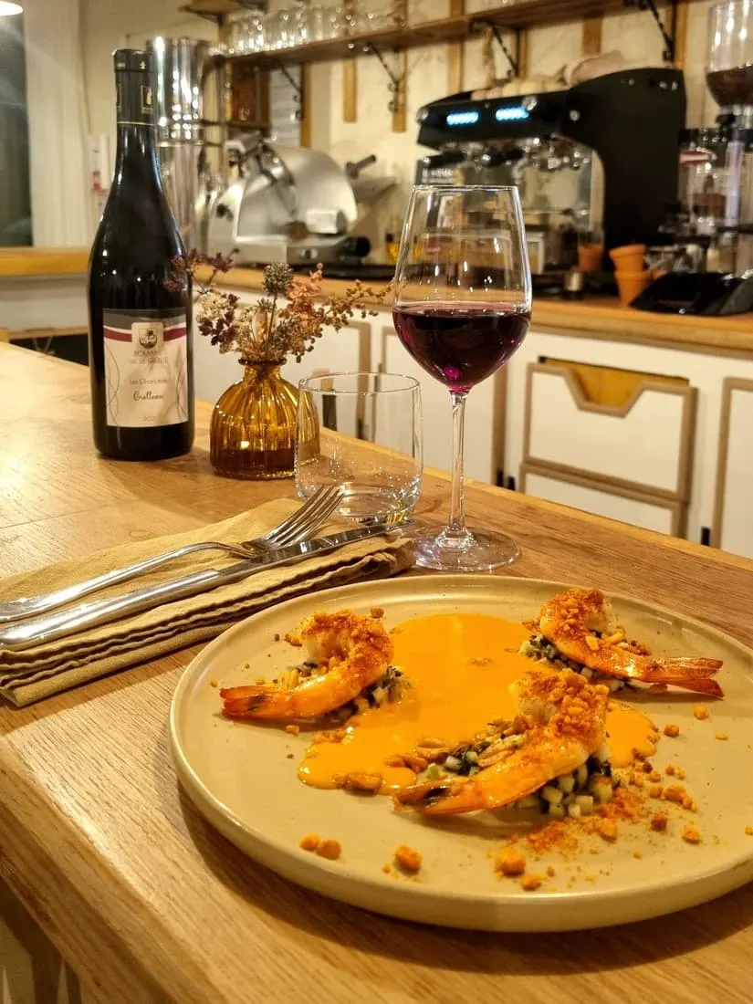 prawns on a plate with red wine in the background at le petit basson in troyes france