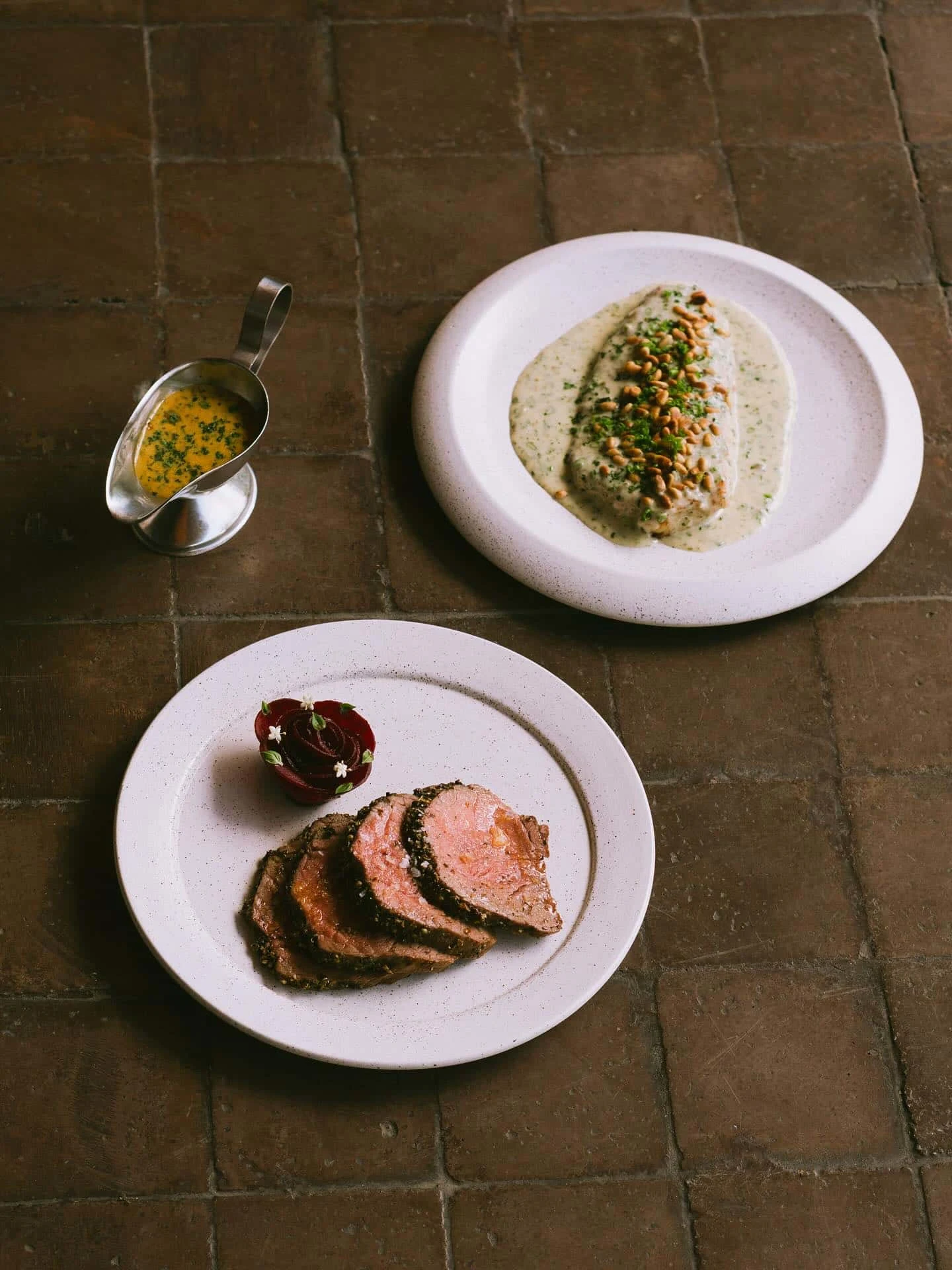 Roast lamb, fish topped with pine nuts