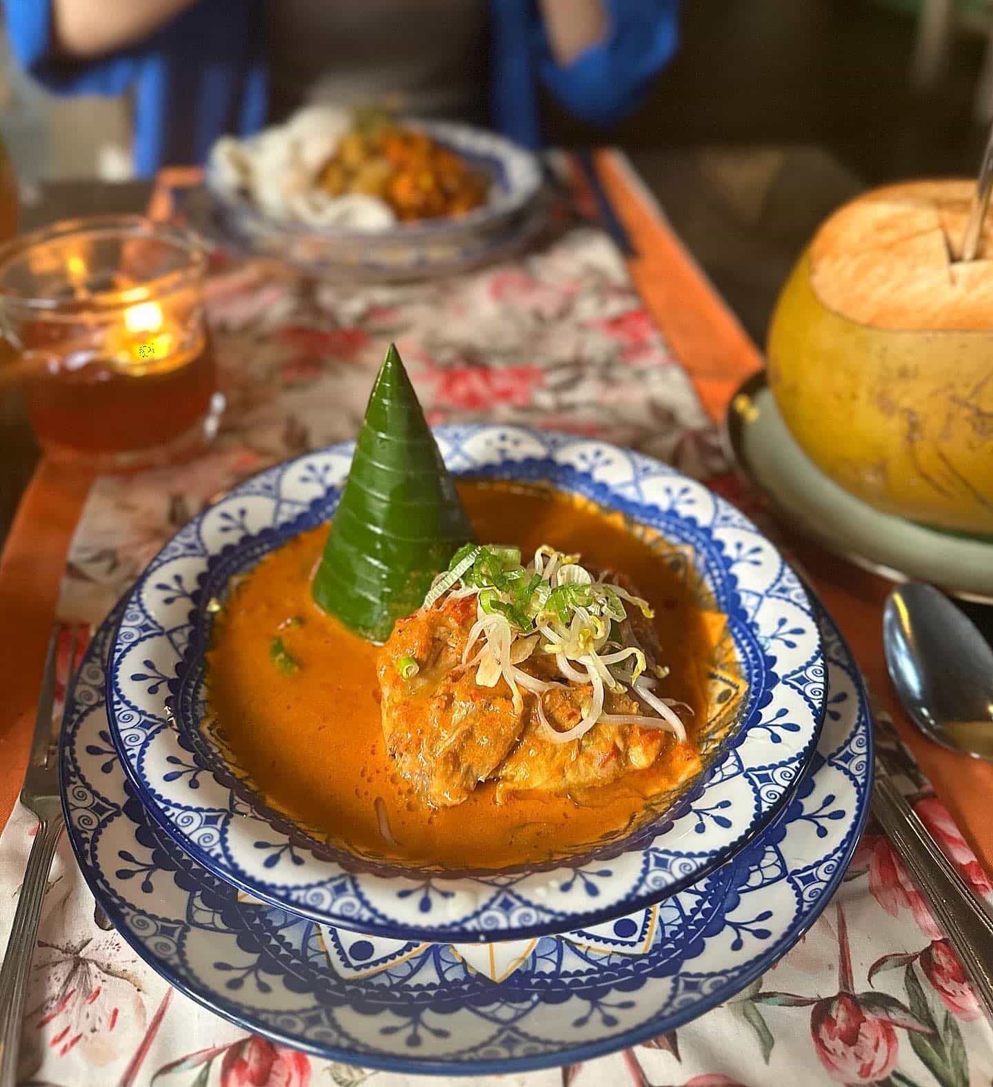 gulai ayam (Indonesian chicken curry) topped with curled banana leaf triangle