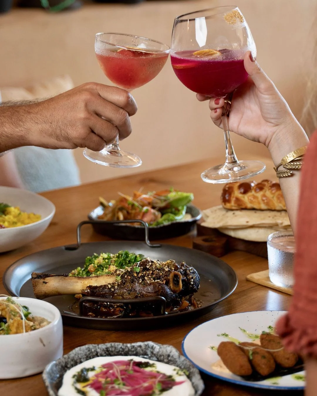 An array of dishes ideal for sharing including lamb shank, breads, hummus