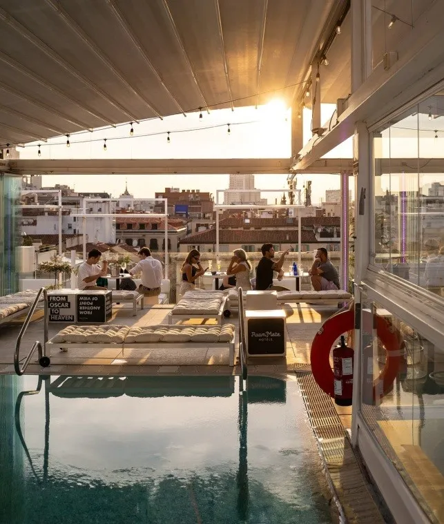 a rooftop pool and bar at sunset at room mate oscar hotel in madrid spain