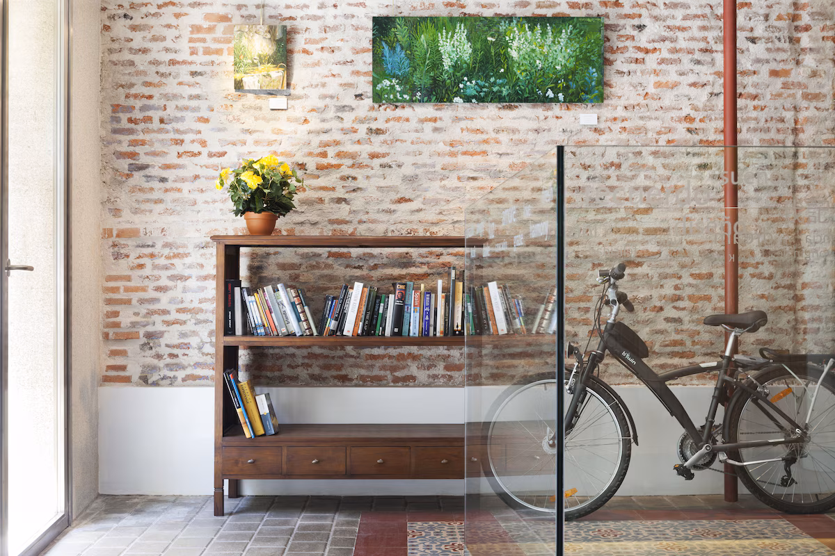 a bicycle next to a wooden bookcase in front of an exposed brick wall at artrip hotel in madrid spain