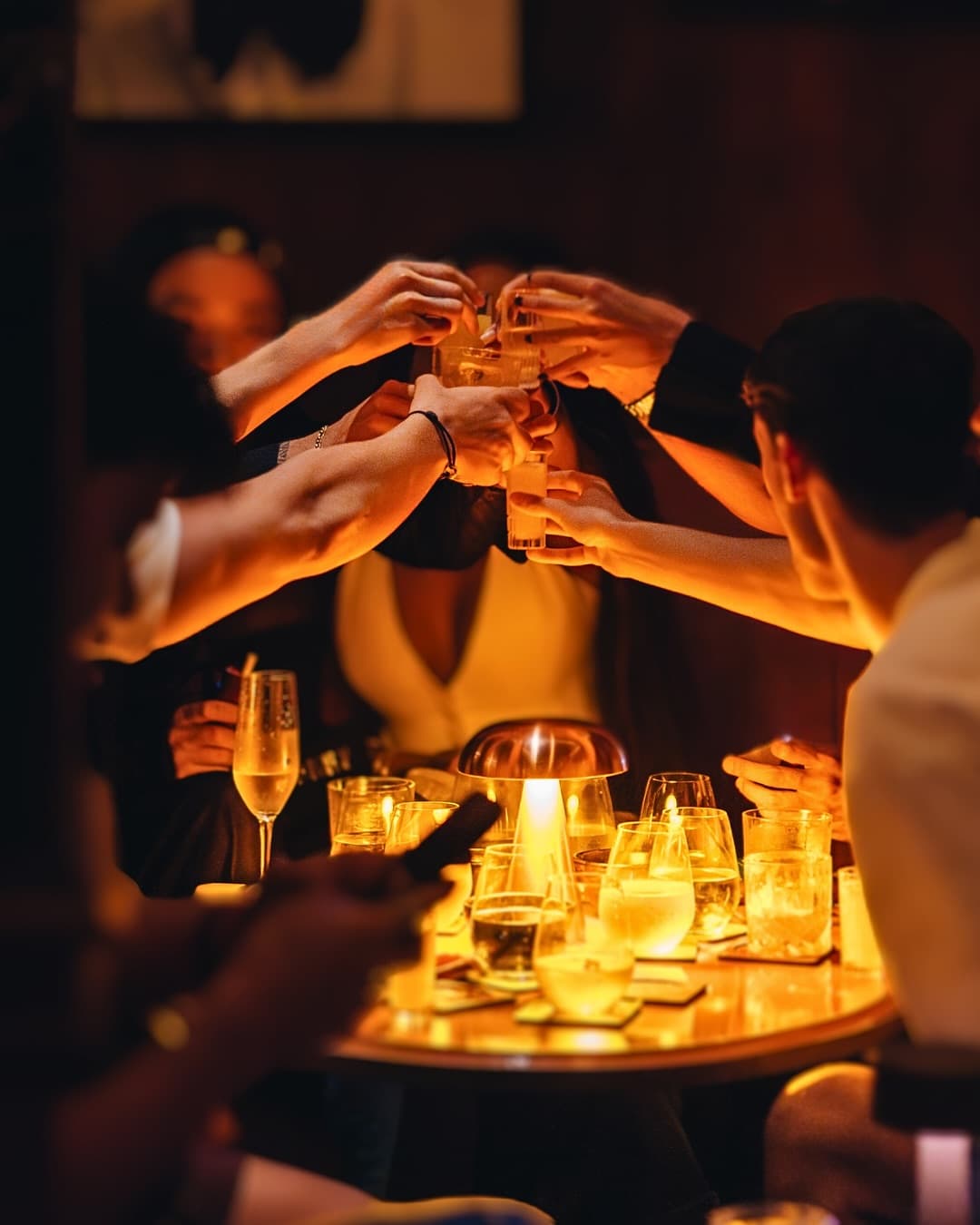 Friedns cheersing over whiksey and champagne