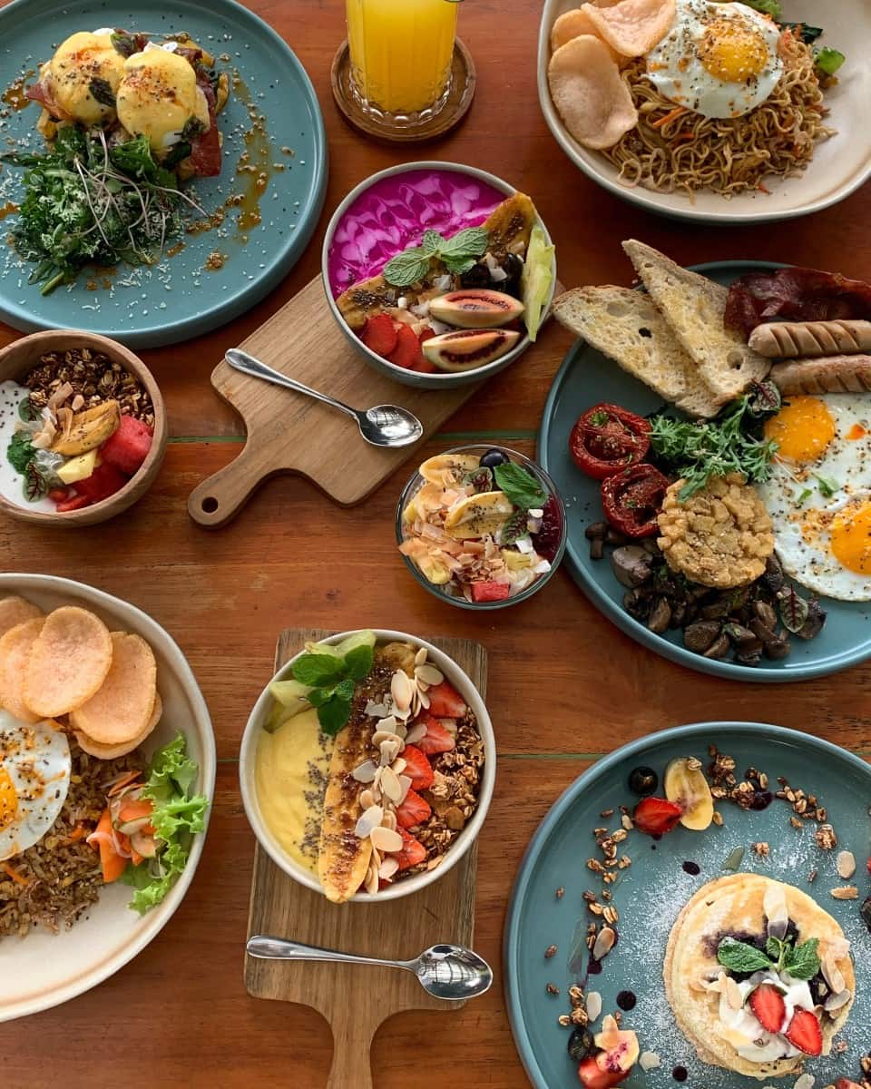 An array of brunch meals, including pancakes, smoothies bowls, fry up, and nasi goreng