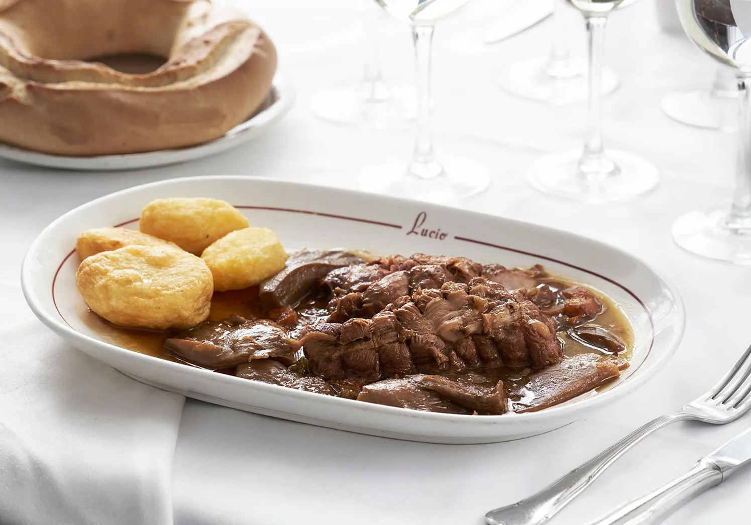 a beef steak with potatoes on a white plate from casa lucio restaurant in madrid spain