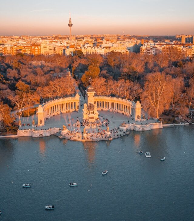 the cityscape of madrid provides a backdrop to retiro park