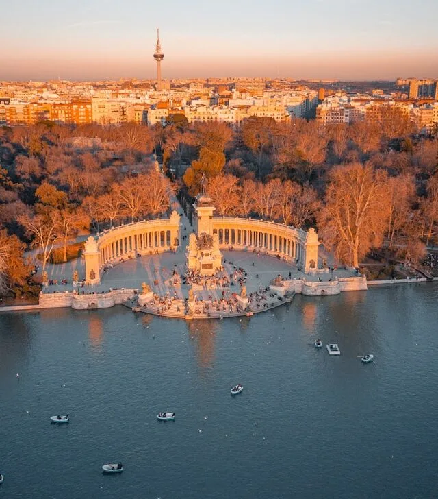 the cityscape of madrid provides a backdrop to retiro park