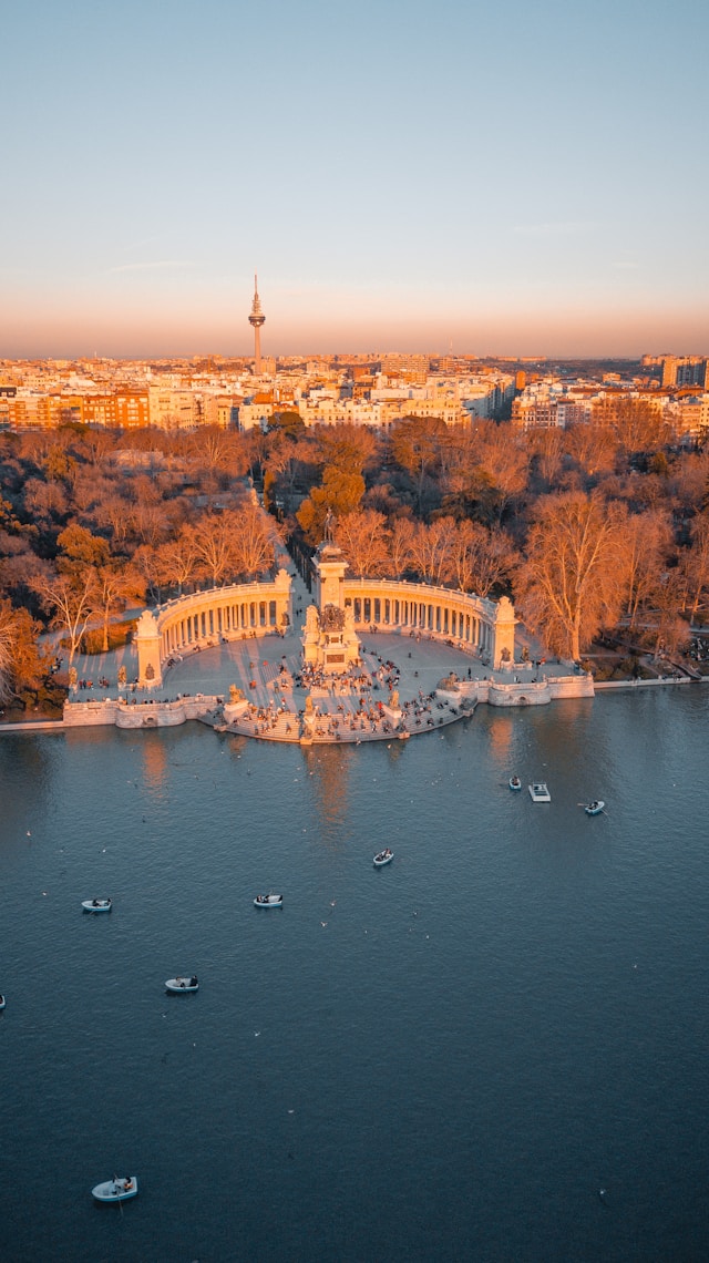 the cityscape of madrid provides a backdrop to retiro park