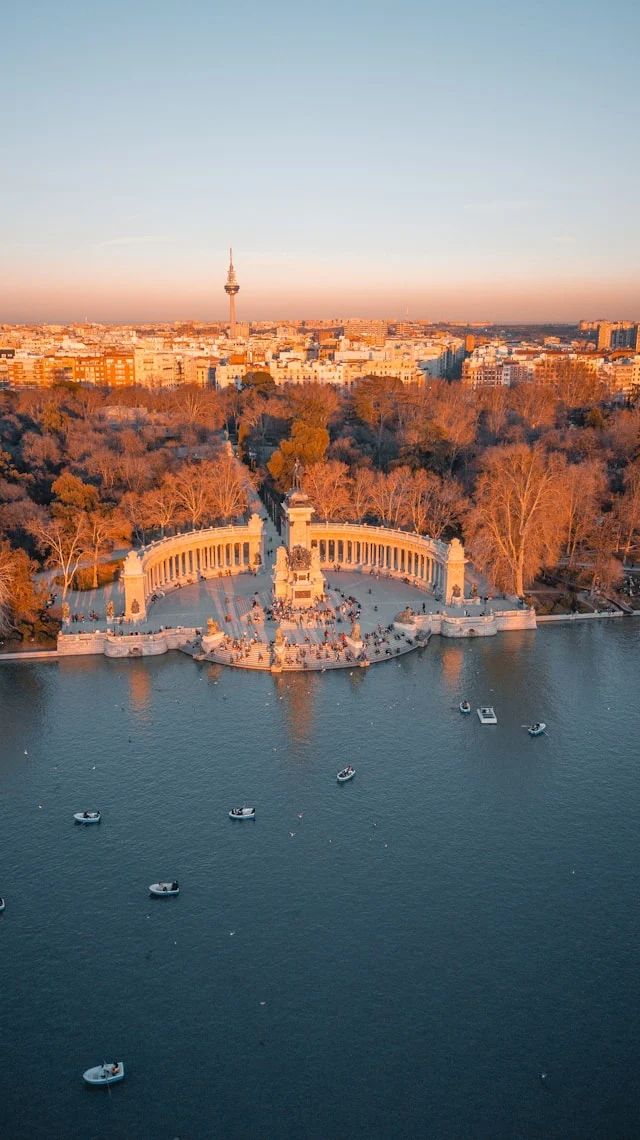 the cityscape of madrid provides a backdrop to retiro park