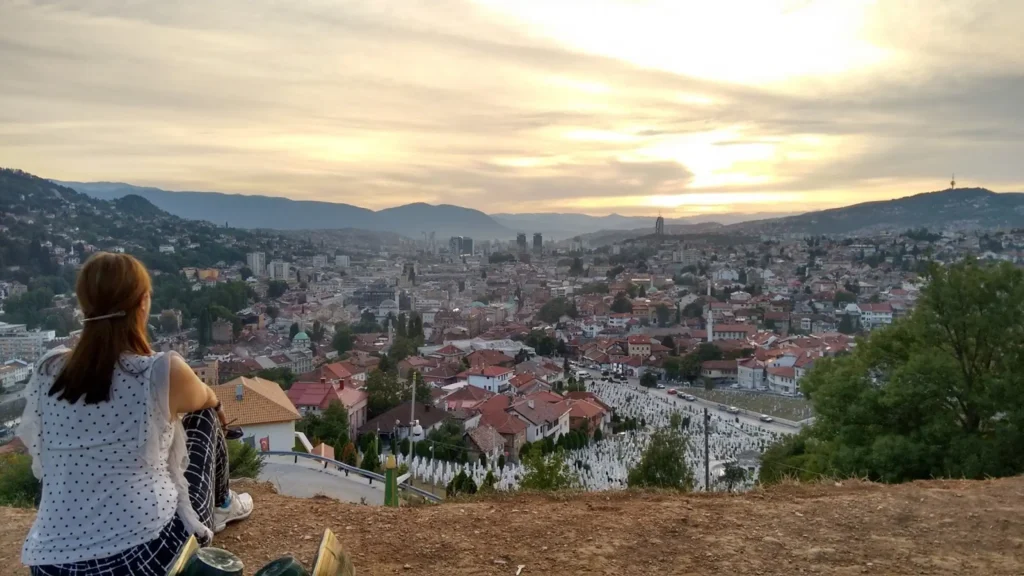 a woman watches sunset over sarajevo bosnia and herzegovina from the yellow fortress
