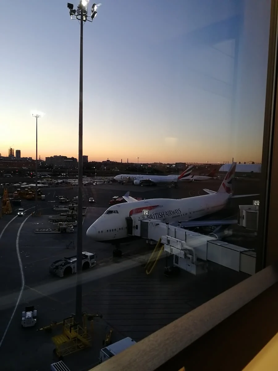 a british airways boeing 747 with an emirates boeing 777 in the background at boston logan airport