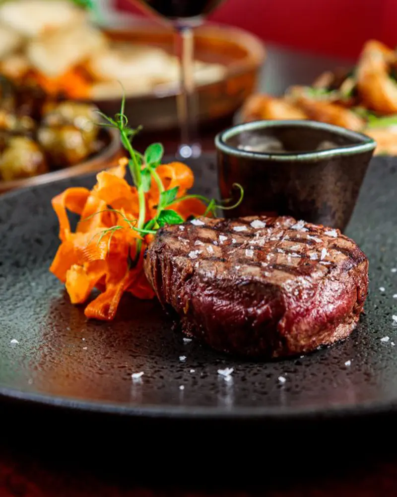 steak served on a black plate with a salt garnish at ryleigh's rooftop steakhouse in the mayson hotel point village dublin ireland
