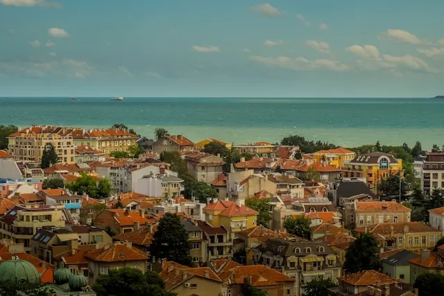 rooftops in the old town of burgas bulgaria looking out onto the black sea with ships in the background