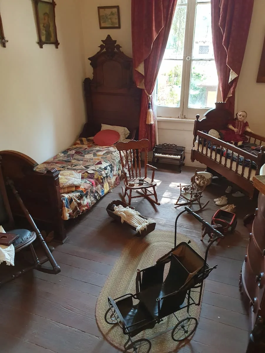 a 19th century bedroom with a wooden bed and chairs in whaley house museum old town san diego california usa