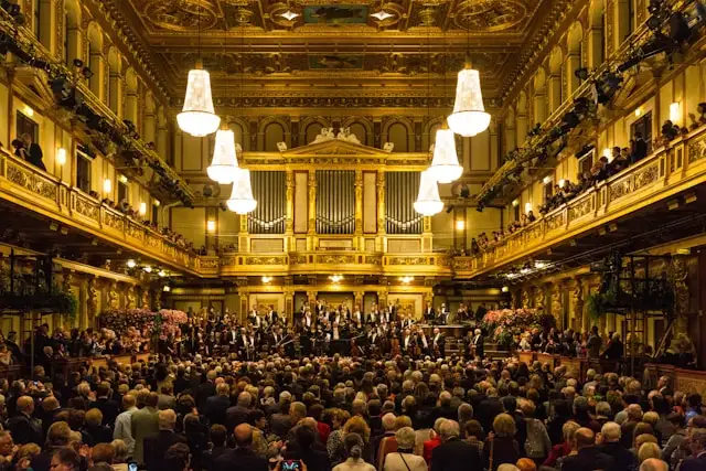 the grand golden hall of musikverein vienna austria with an orchestra in the background and spectators in the foreground