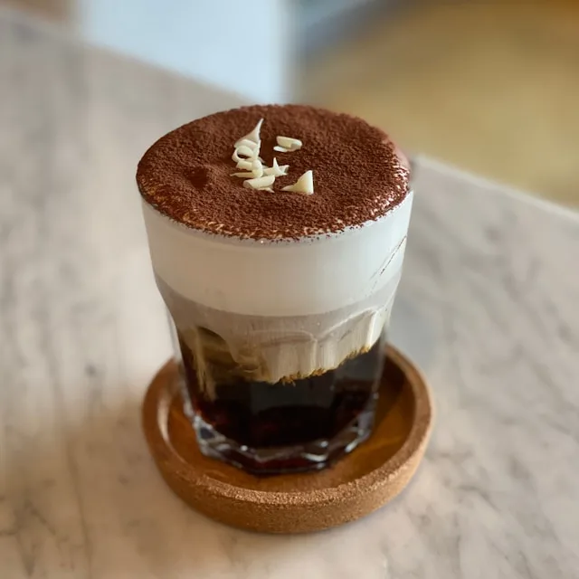 a glass of einspanner coffee served in a viennese coffee house