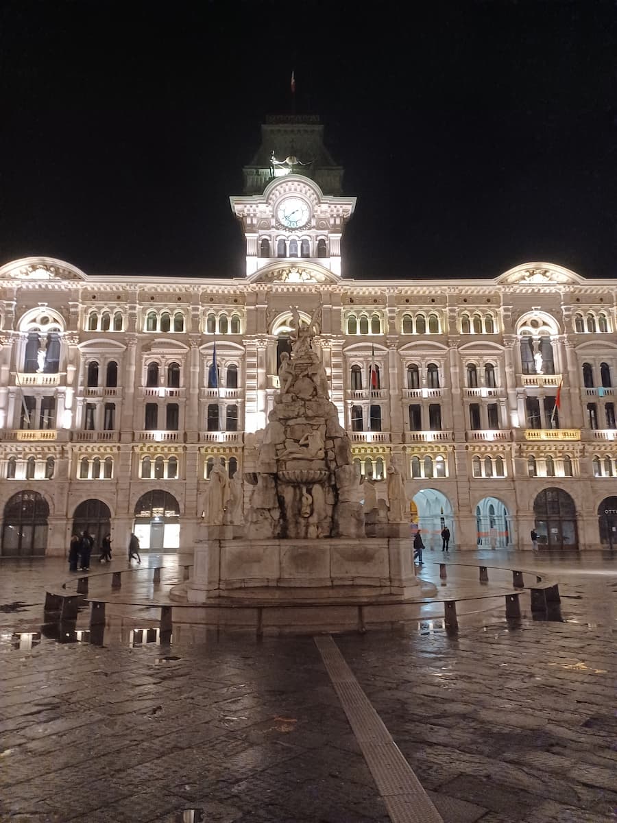 the triestemetro building with a statue in front on piazza unita d'italia trieste italy