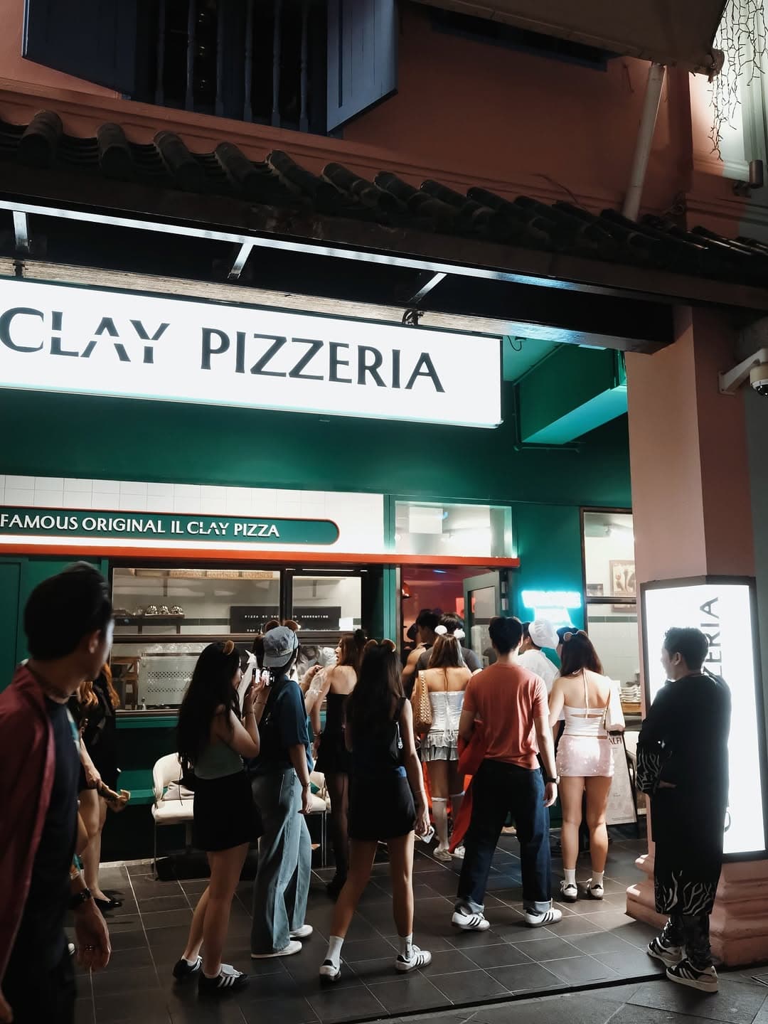 Outside entrance of Il Clay with people lining out the door