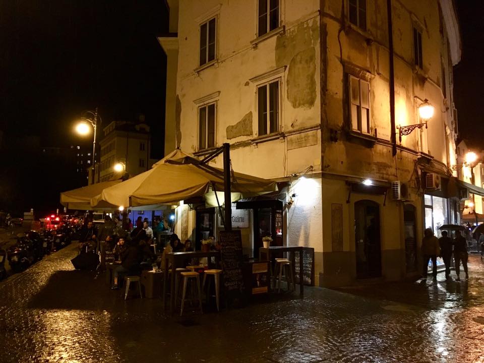 super bar stella occupies a rundown building on a street corner with tables outside in trieste italy