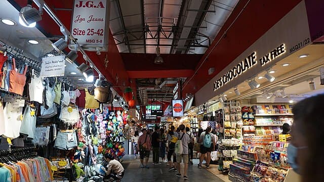Inside Bugis Market with vendors selling clothes and chocolate