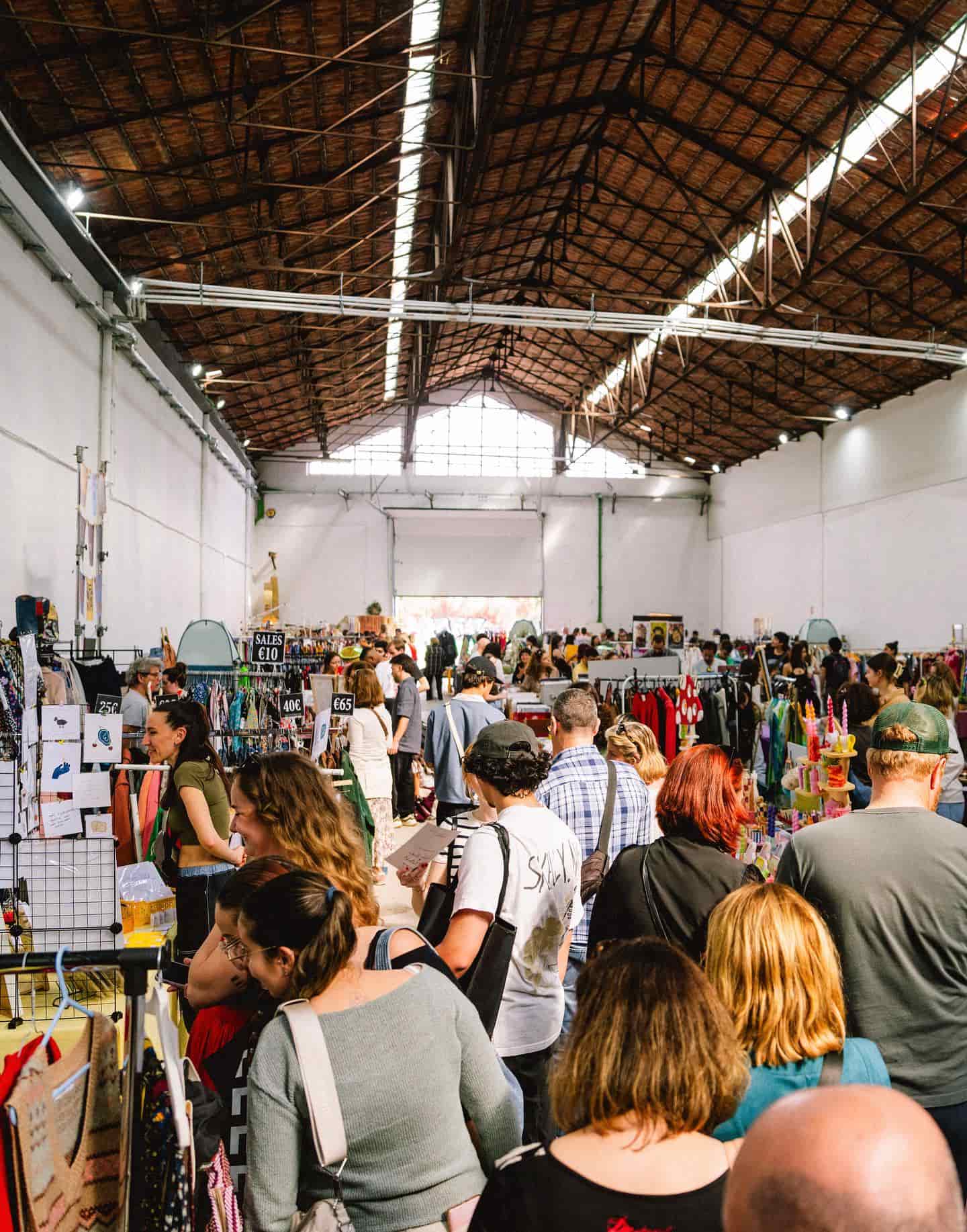 Shoppers at the flea market doing unsual things to do in Lisbon