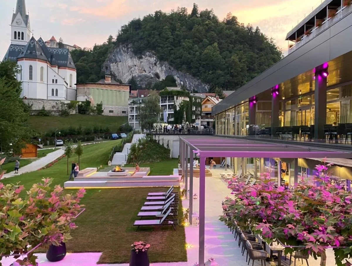 pink roses under a veranda on a balcony overlooking a garden at bled rose hotel lake bled slovenia