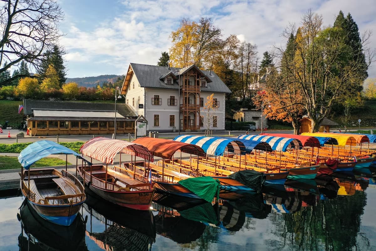 wooden boats with colorful awnings on lake bled slovenia with hotel starkl in the background