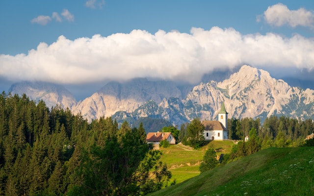 a church in the logar valley slovenia with the kamnik alps in the background