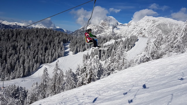 a person on a ski lift above the snow covered alps mountains in krvavec slovenia