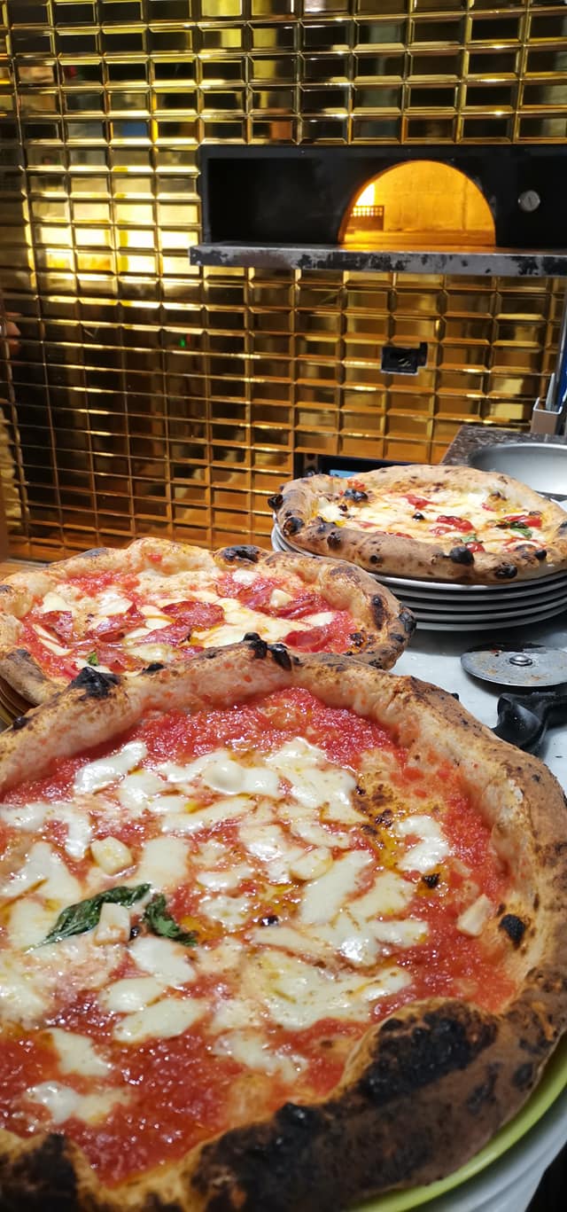 three neapolitan pizzas from a woodfired oven at bianco pizzeria trieste italy
