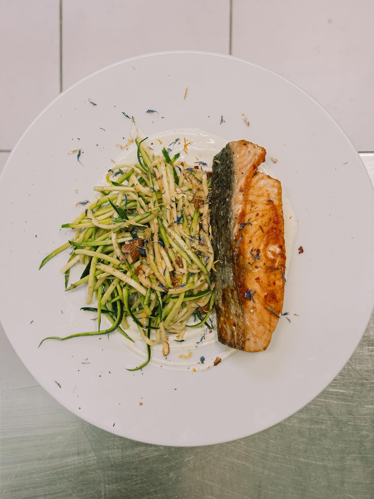 harissa salmon with zucchini on a white plate at hops beerstro restaurant and bar in trieste italy