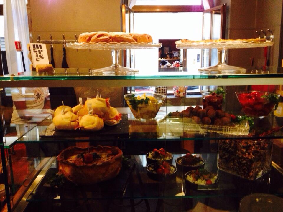 a glass cabinet containing cakes and pastries at osteria marise restaurant in trieste italy