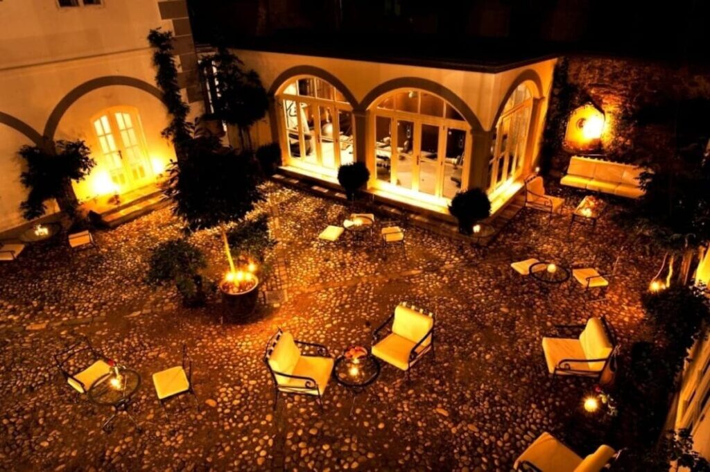 a dimly lit courtyard with outdoor chairs and tables at antiq palace hotel in old town ljubljana slovenia