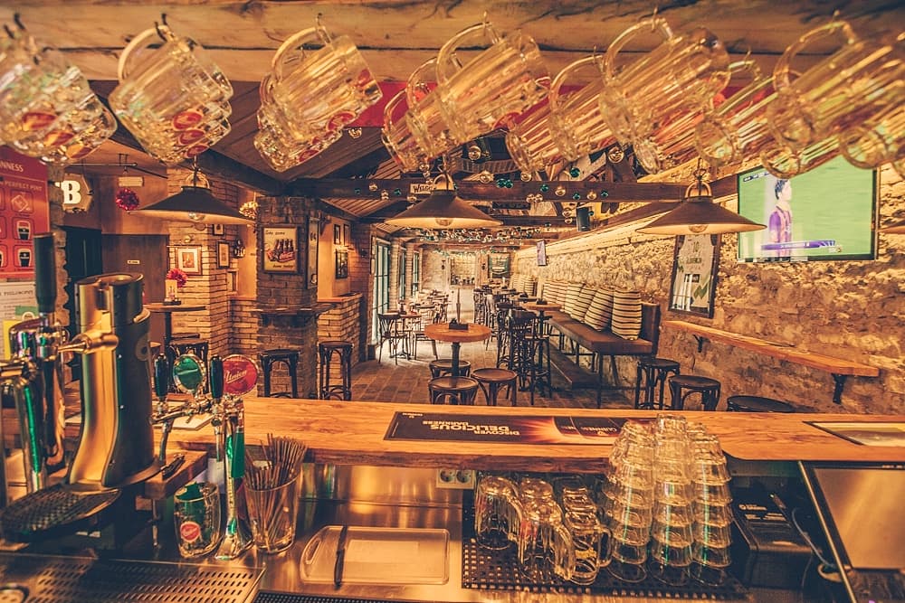 beer glasses hang above a bar at cutty sark pub ljubljana slovenia