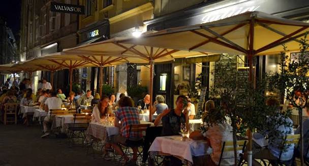 people dining alfresco at tables under an awning at julija restaurant in old town ljubljana slovenia
