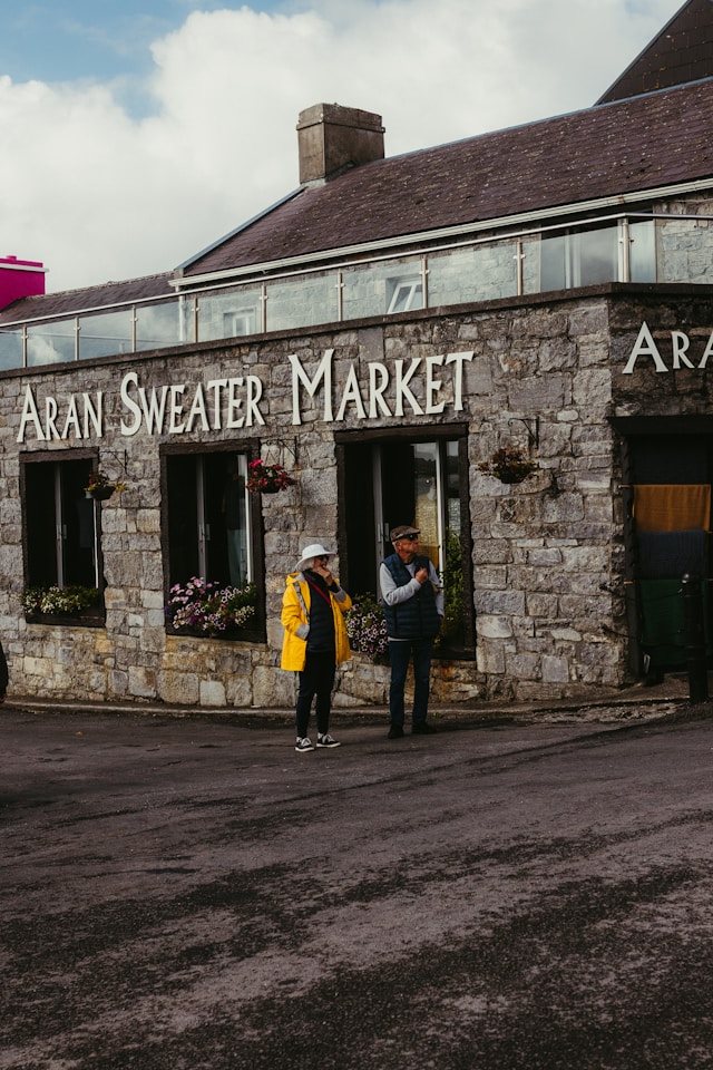 two people stand outside the aran sweater market on the aran islands ireland