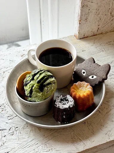 A tray of coffee, cookies, ice cream, and cakes