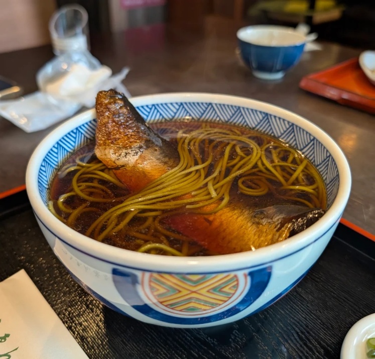 Bowl of noodles in a matcha soup with fish